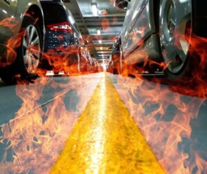 Cars on a ferry with fire surrounding them assumedly caused by lithium batteries